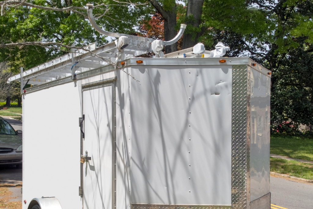 A utility trailer for a business that was outfitted with custom roof racks to hold ladders. 