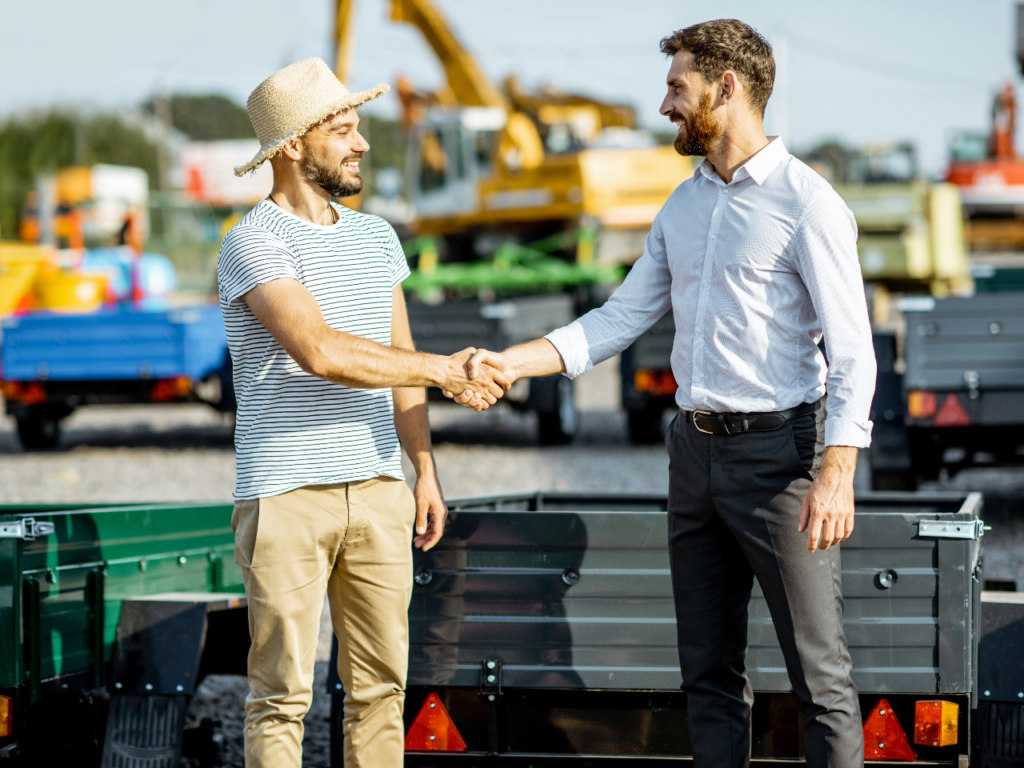 An Albuquerque trailer sales dealer and customer shake hands after a sale. 